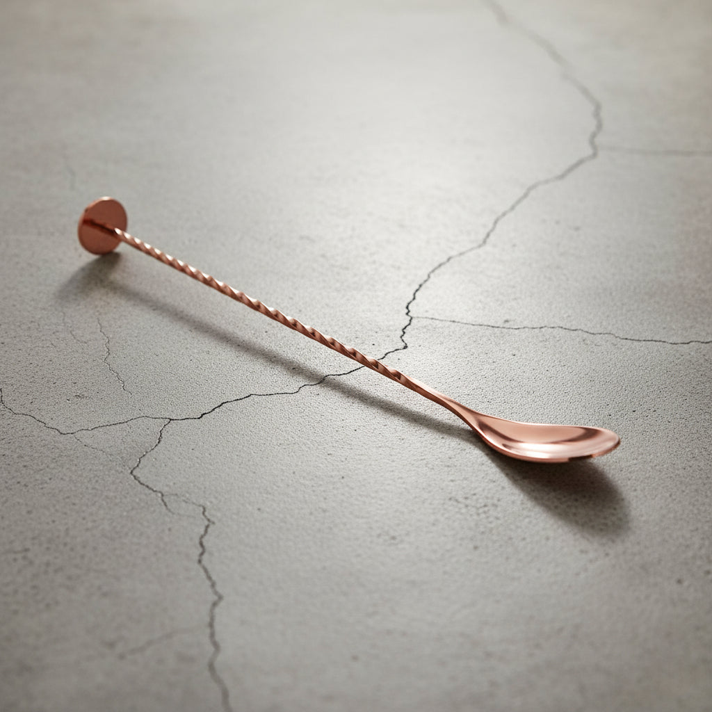 Copper bar spoon on a textured gray surface