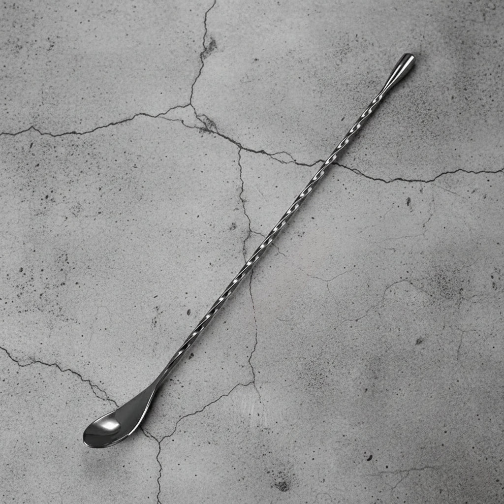 Metallic mixing blck spoon on a textured concrete surface
