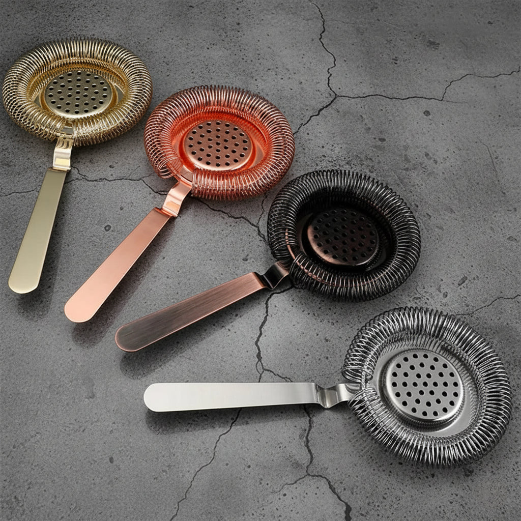 Set of five metal cocktail strainers on a textured gray surface