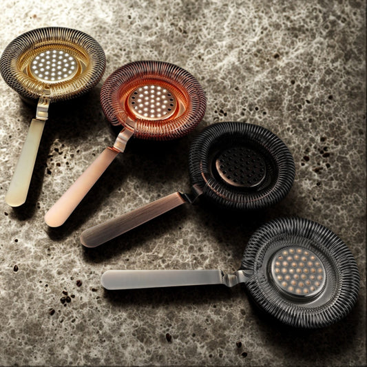 Set of five strainers with different designs on a textured surface