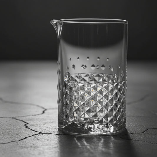 Clear glass pitcher with diamond pattern on a dark surface
