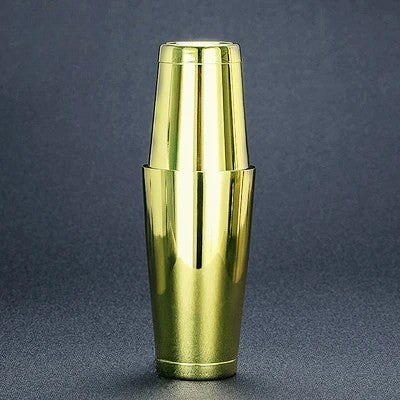 Gold metallic cocktail shaker on a dark gray background