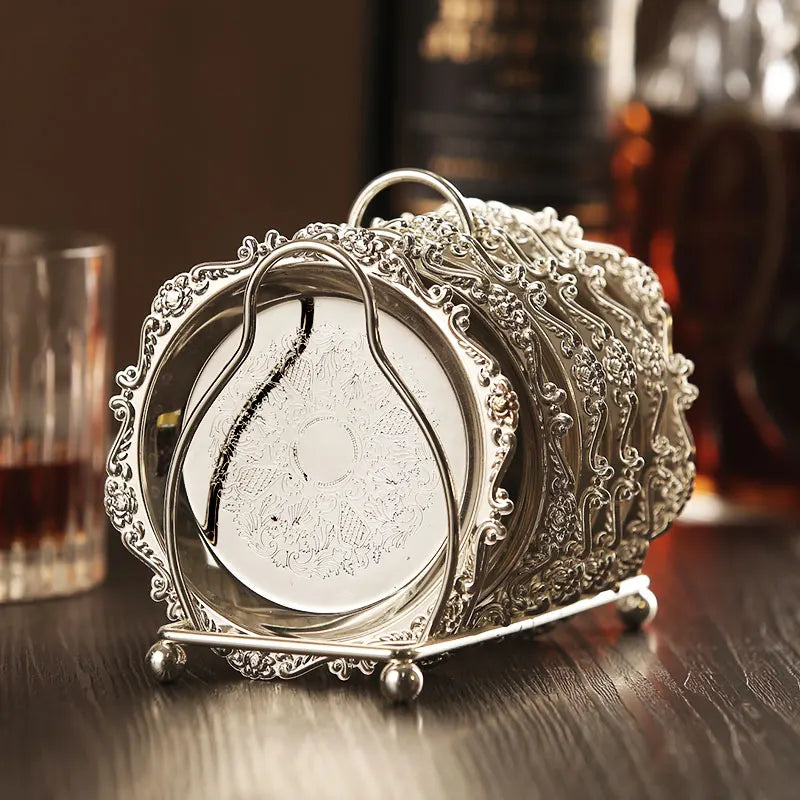 Decorative silver holder with a teardrop-shaped object on a wooden surface.