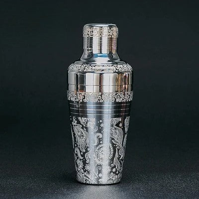 Decorative cocktail shaker with intricate patterns on a black background